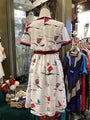 White dress with sailboat pattern on a mannequin in a store setting.
