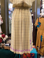 Beige checkered dress with floral details on a mannequin in a store setting.