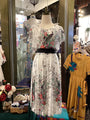 Floral dress on a mannequin with a yellow dress in the background