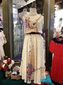 Mannequin wearing a floral dress in a store setting with other clothing items.