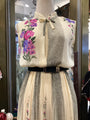 Mannequin wearing a dress with floral embroidery in a store setting