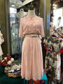 Mannequin wearing a pink outfit with a blurred store interior in the background
