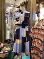 Vintage clothing display with a colorful striped dress on a mannequin in a store setting.