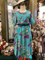 Colorful dress on a mannequin in a store setting with other clothing items.