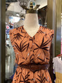 Mannequin wearing a brown dress with leaf pattern in a store setting