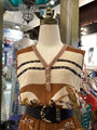 Mannequin wearing a patterned top with a belt in a store setting