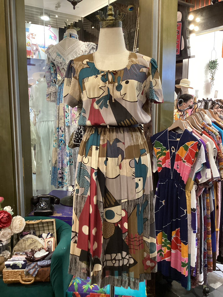 Colorful dress on a mannequin in a store setting with various clothing items around.