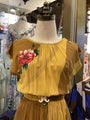 Yellow dress with floral embroidery on a mannequin in a store setting