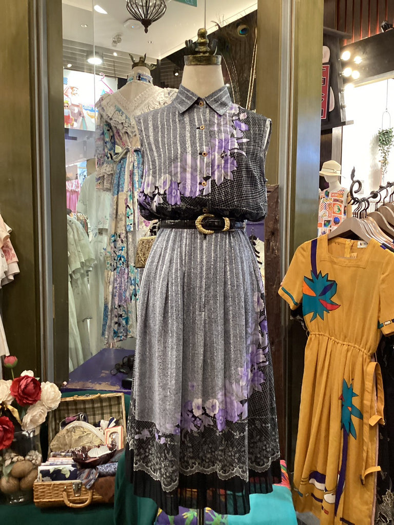 Mannequin wearing a patterned dress with a belt in a store setting