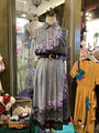 Mannequin wearing a patterned dress with a belt in a store setting