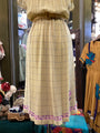Plaid dress with floral trim on a mannequin in a store setting