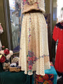 Vintage-style dress with floral patterns on a mannequin in a store setting.