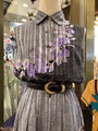 Mannequin wearing a patterned shirt with a scarf and skirt in a store setting