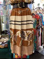 Long brown skirt with elephant design on a mannequin in a clothing store.
