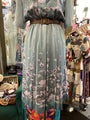 Floral dress on a mannequin in a store setting with various clothing items in the background.