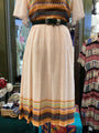 Traditional dress with a belt on a mannequin against a blurred background