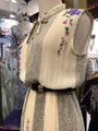 Mannequin wearing a floral embroidered vest in a store setting