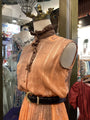 Mannequin wearing a vintage dress with intricate details in a store setting