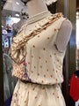 Mannequin wearing a polka dot dress with ruffled sleeves in a store setting