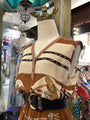 Mannequin wearing a patterned shirt with suspenders in a store setting