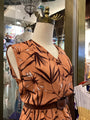 Mannequin wearing a brown floral-patterned dress in a store setting
