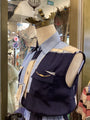 Mannequin wearing a navy vest with a gold chain detail in a store setting