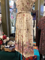 Floral dress on a mannequin in a store setting with other clothing items.