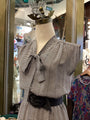 Black and white striped top on a mannequin with a blurred store interior background