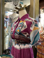 Mannequin wearing a colorful patterned shirt and skirt in a store setting