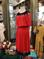 Red dress on a mannequin in a store with other dresses and decor.