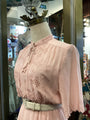 Pink lace blouse on a mannequin in a store setting
