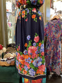 Colorful floral dress on a mannequin with another dress in the background.