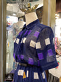 Mannequin wearing a blue dress with geometric patterns in a store setting