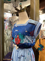 Mannequin wearing a blue dress with underwater-themed design in a store setting.