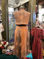 Vintage dress on a mannequin in a store setting with other clothing items.
