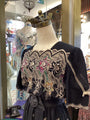 Mannequin wearing a black embroidered top in a store setting