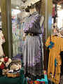 Mannequin wearing a patterned dress with a belt in a store setting
