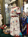 Mannequin wearing a white dress with colorful patterns in a store setting