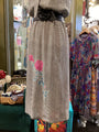 Long dress with floral design on a mannequin in a store setting