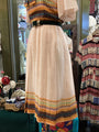 Mannequin wearing a colorful top and patterned skirt in a store setting