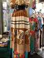 Mannequin wearing a patterned skirt with animal designs in a clothing store.