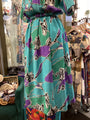Teal dress with purple and black abstract pattern in a store setting