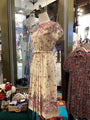 Vintage dress on a mannequin in a store setting with floral patterns