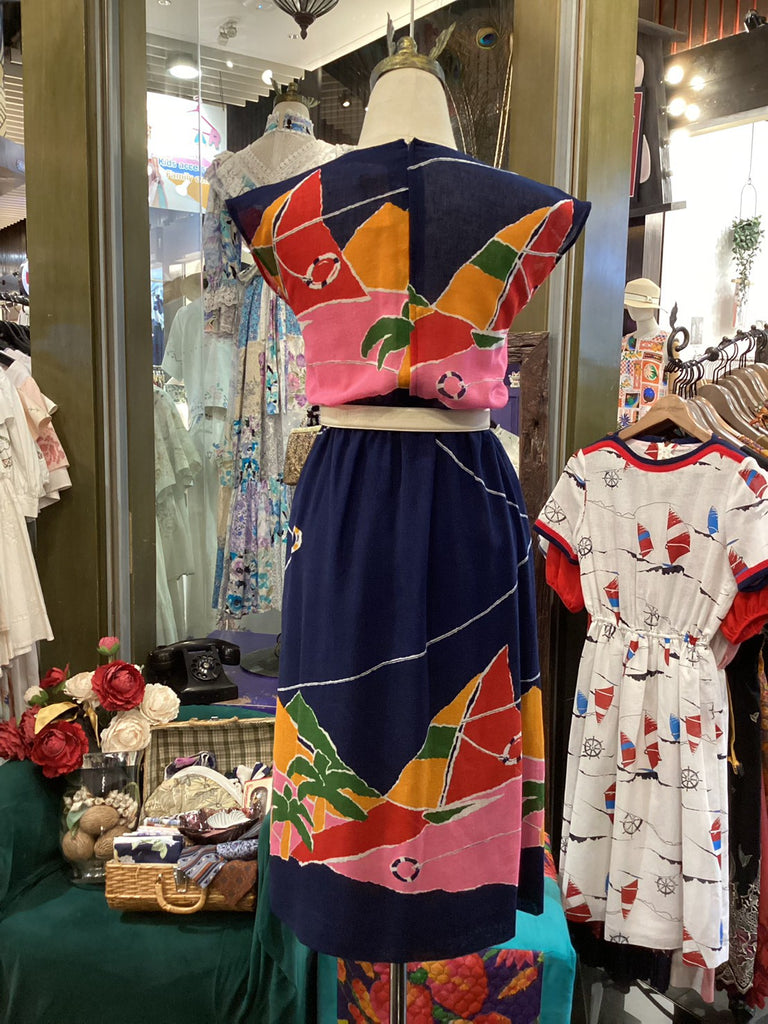 Mannequin wearing a colorful dress with abstract patterns in a store setting.