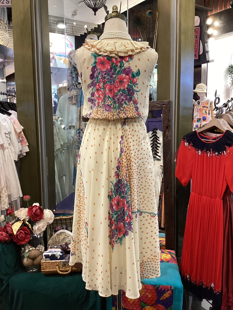 Mannequin wearing a floral dress with a colorful top in a store setting.