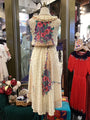 Mannequin wearing a floral dress with a colorful top in a store setting.