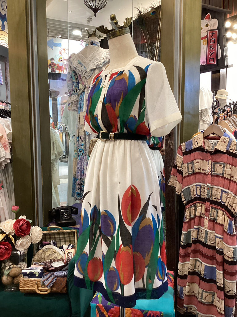 Mannequin wearing a colorful dress with abstract patterns in a store setting.