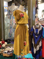 Yellow dress with floral embroidery on a mannequin in a store setting.