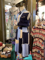 Mannequin wearing a patterned dress in a store setting with other clothing items.
