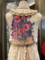 Mannequin wearing a floral and polka dot dress with a ruffled collar.